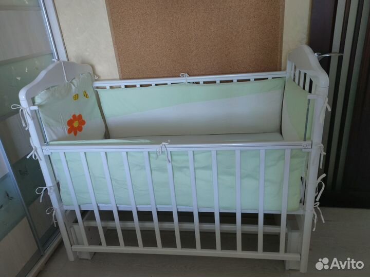 Белая детская кроватка с маятником