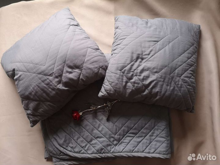 Серое стеганое покрывало и декоративные подушки