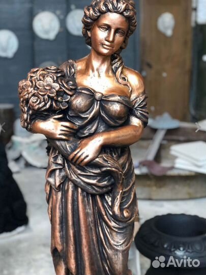 Статуя девушки из бетона с букетом